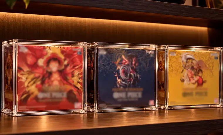 One Piece booster boxes in Slab Bunker acrylic cases on a shelf